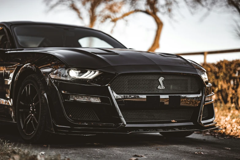 a black car parked in front of a fence