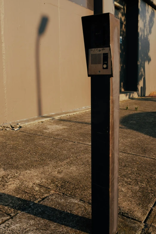 a parking meter in front of a cement wall