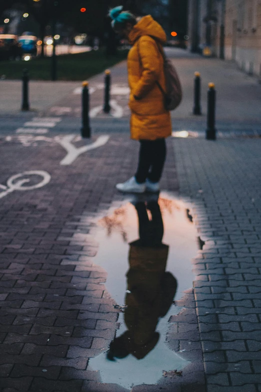 a skateboarder in a yellow jacket skating on a street