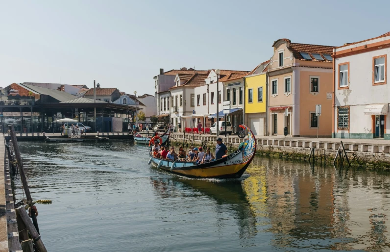 there is a boat with people in the water near buildings