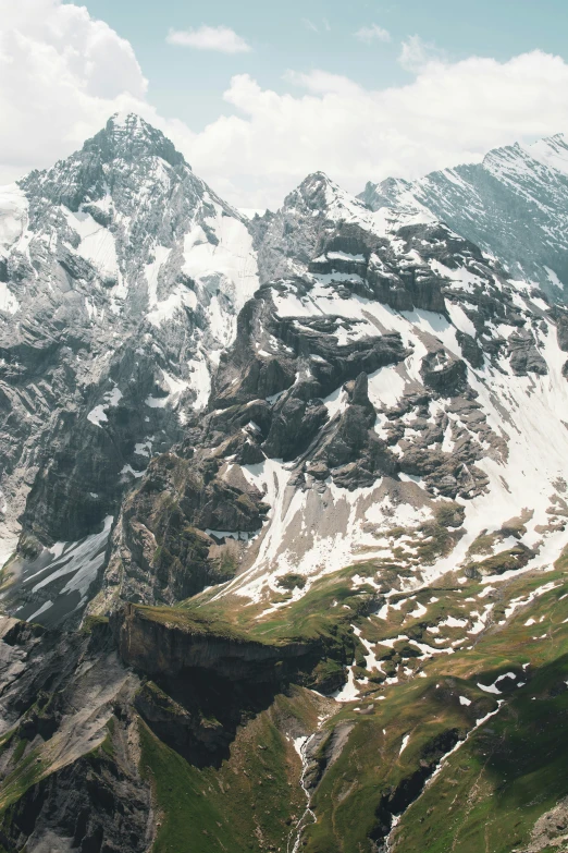 the top of a mountain with green grass