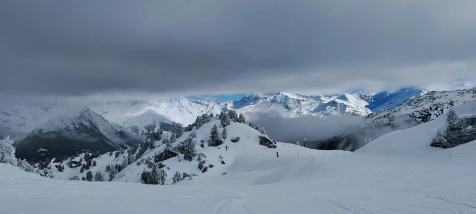 two snow skiers standing at the top of a mountain