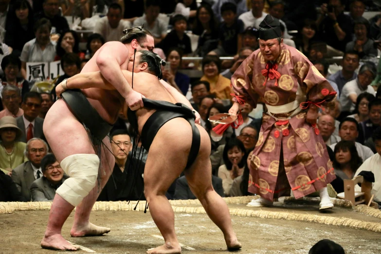 two sumo wrestlers in the middle of an arena