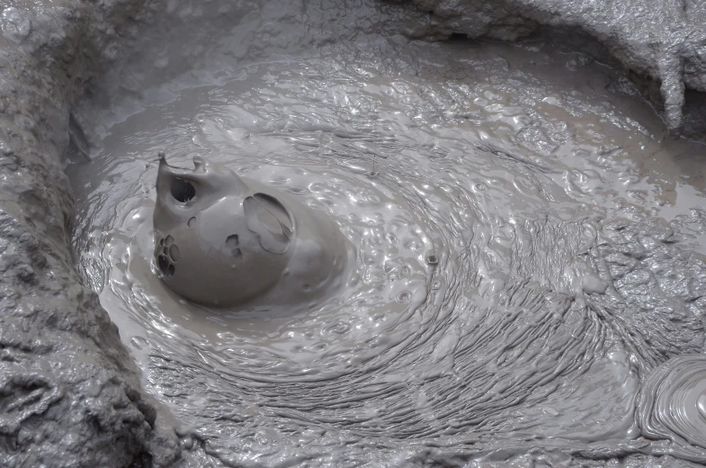 a hole in some kind of rock with water coming out