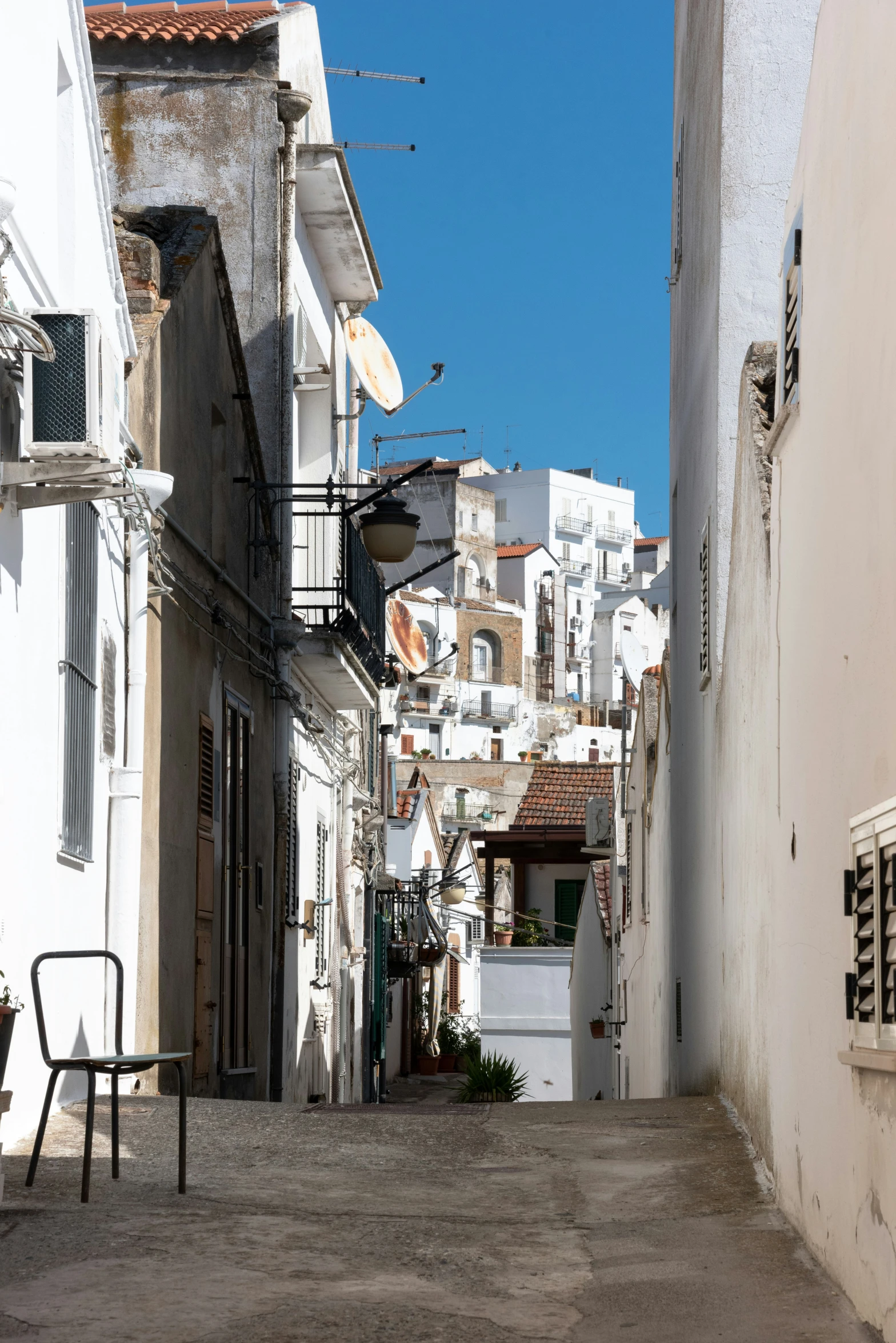 an alley that is narrow with a few buildings in the background