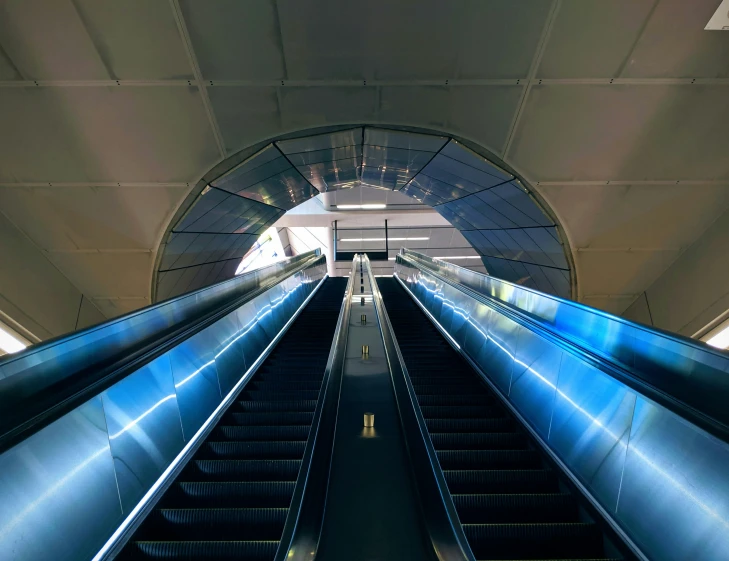 an escalator with a bright, blue glow at the end of it