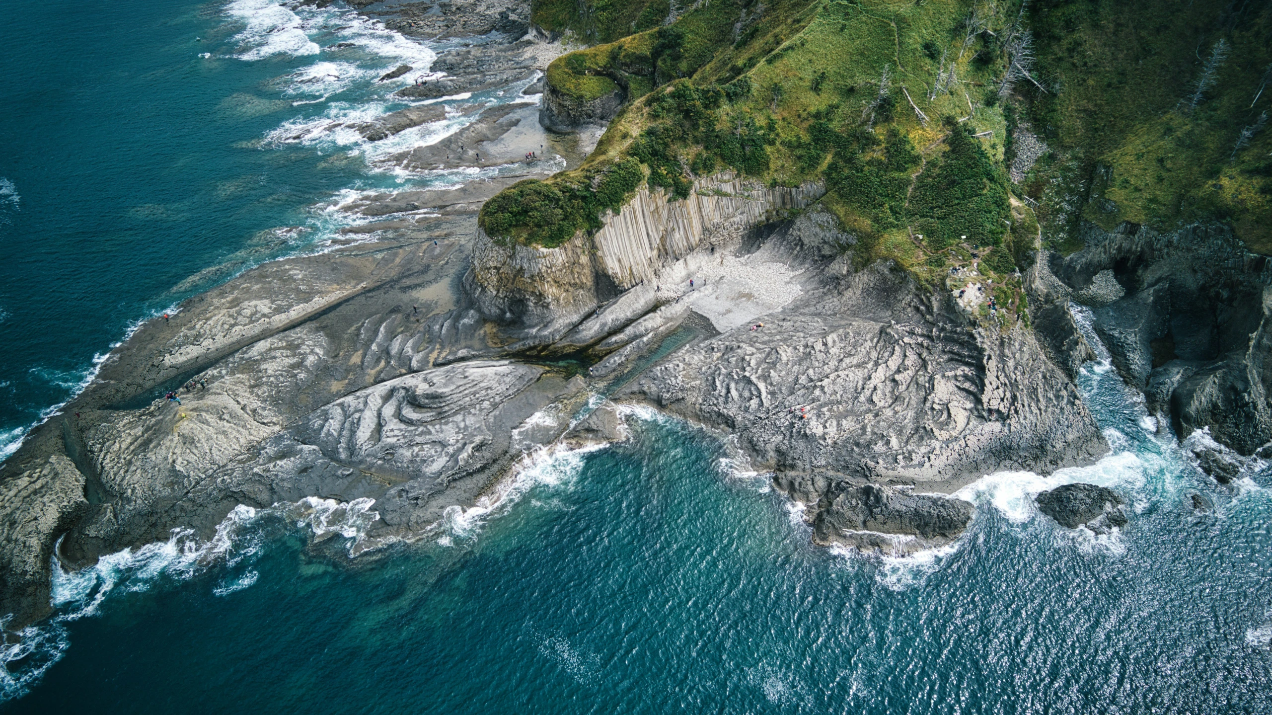 aerial s of a beach with waves and a cliff