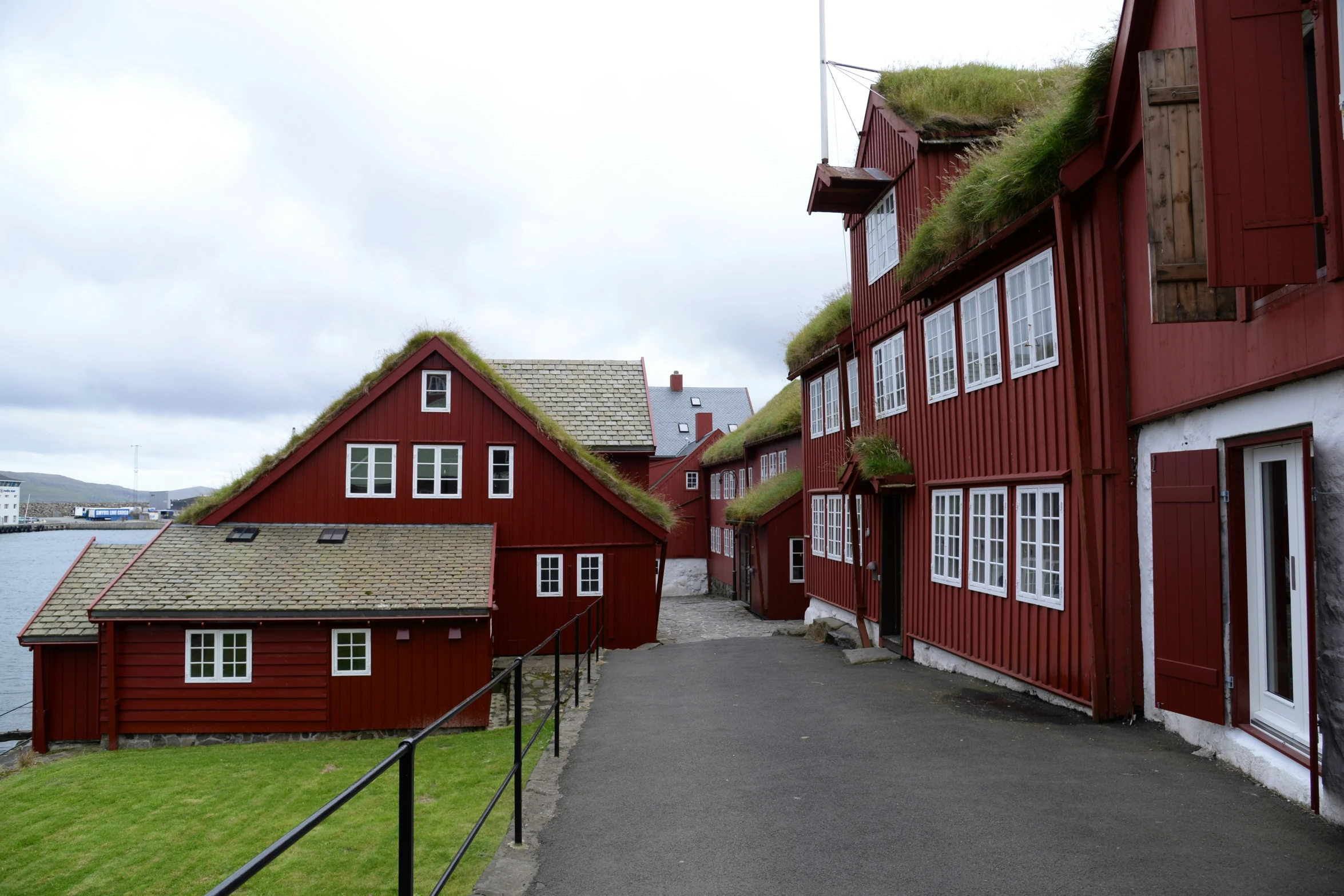 a red house with green roof and windows and a grass roof