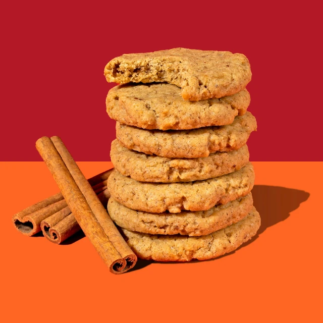 cinnamon and vanilla chocolate chip cookies stacked on an orange background