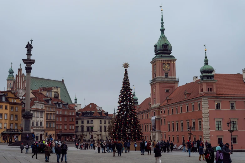 a large christmas tree in a plaza surrounded by tall buildings