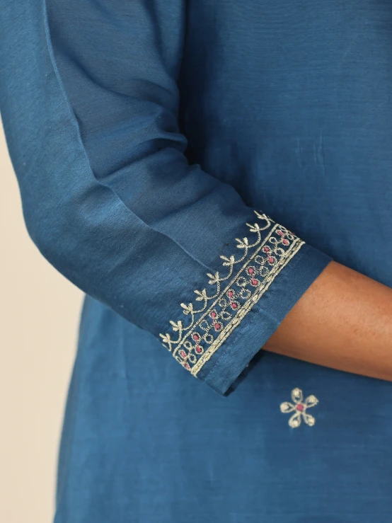 a blue dress has a beaded and gold decoration