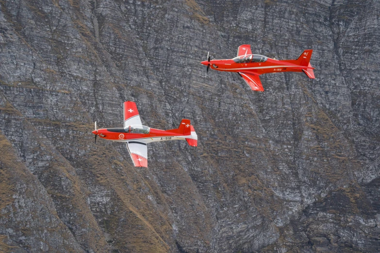 two airplanes flying side by side in the sky