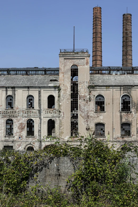 a large industrial building with smoke stacks in the background