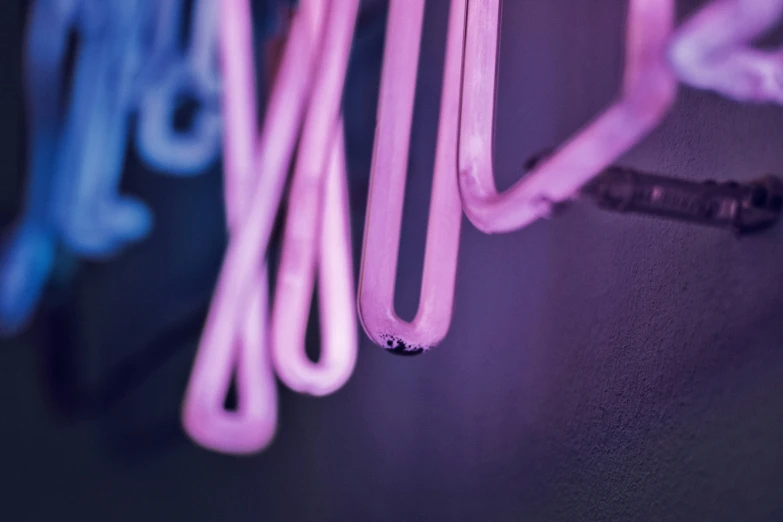 four neon lights are hanging from a wall