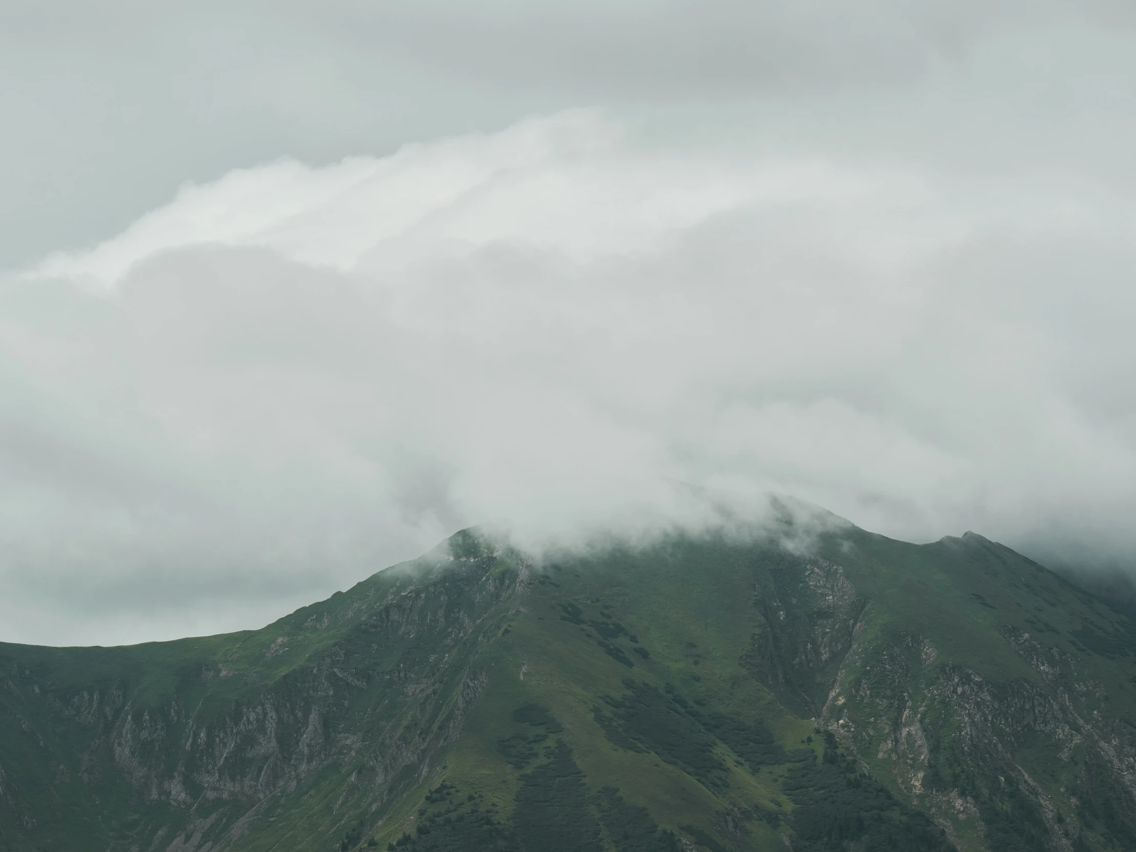 an image of a mountain with mist coming from the top