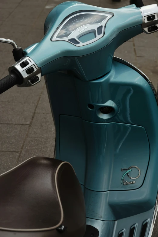 a blue motor scooter is sitting on a sidewalk