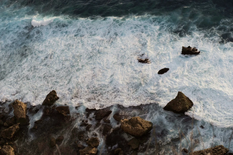 a rocky shoreline that has some waves coming in