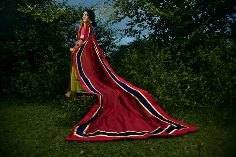 a lady is wearing a red dress in the grass