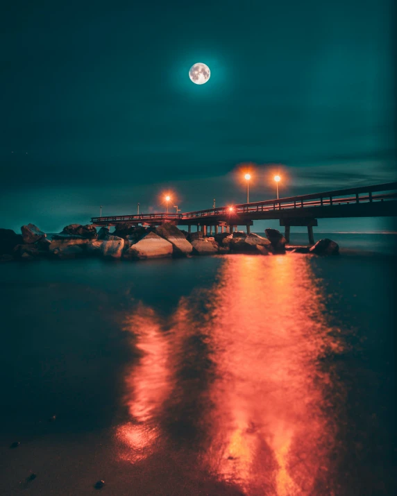 a full moon over the water with a long exposure