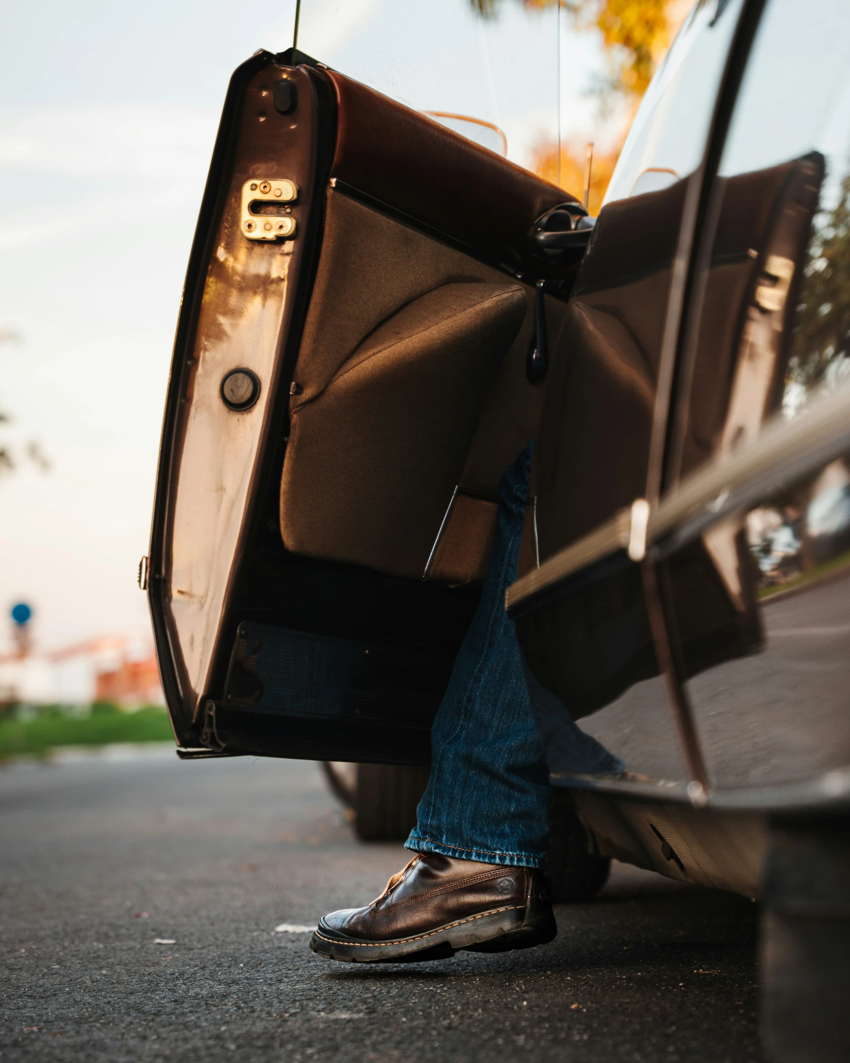 someone's foot sticking out from the side of a parked car with luggage strapped to them