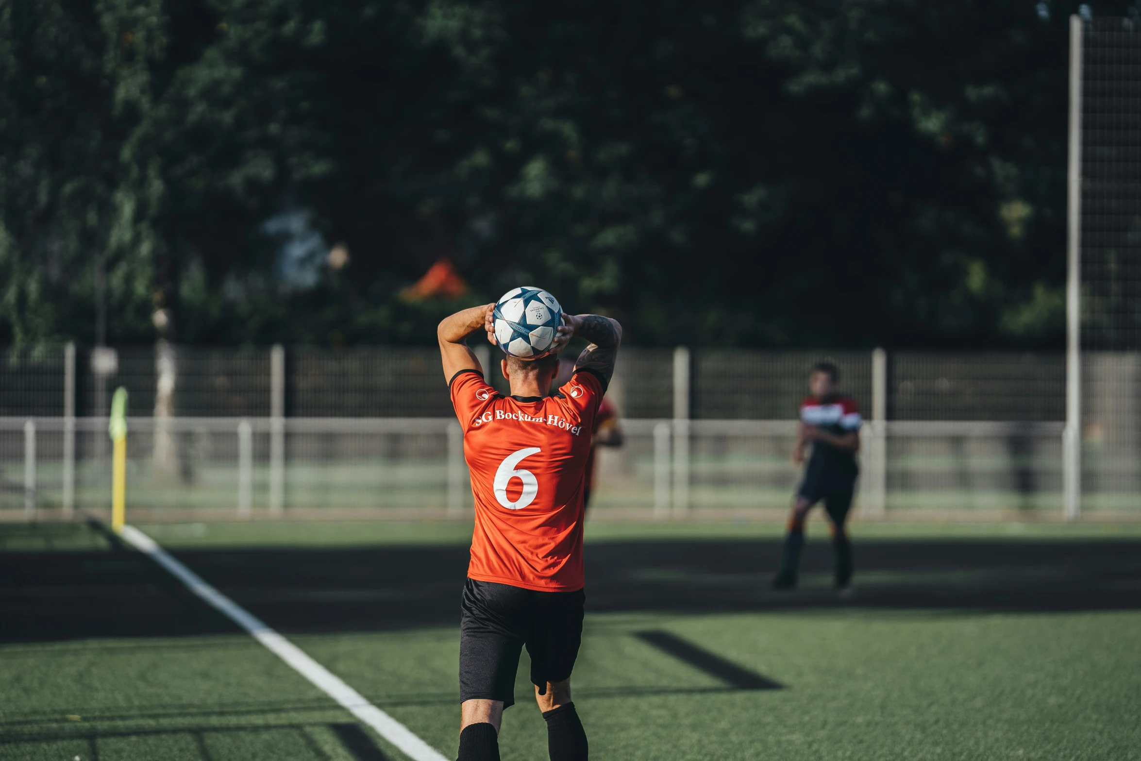 a person on a soccer field holding up a soccer ball