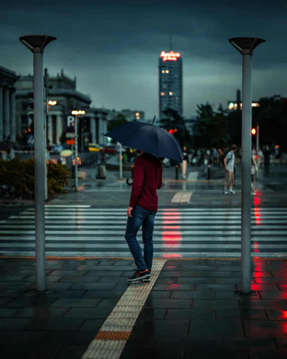 a man with an umbrella is standing on the side walk