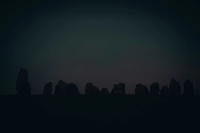 several rocks in the distance at night