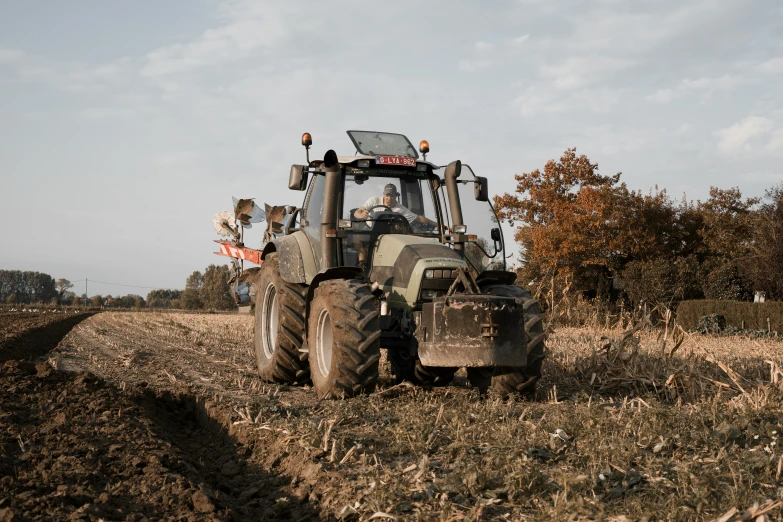 a farmer's tractor plowing the field during the autumn