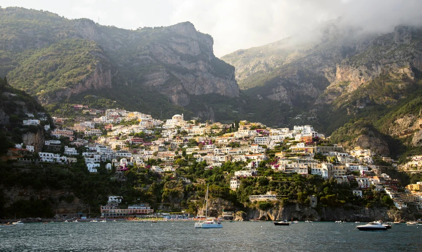 many small boats on the water in front of a town