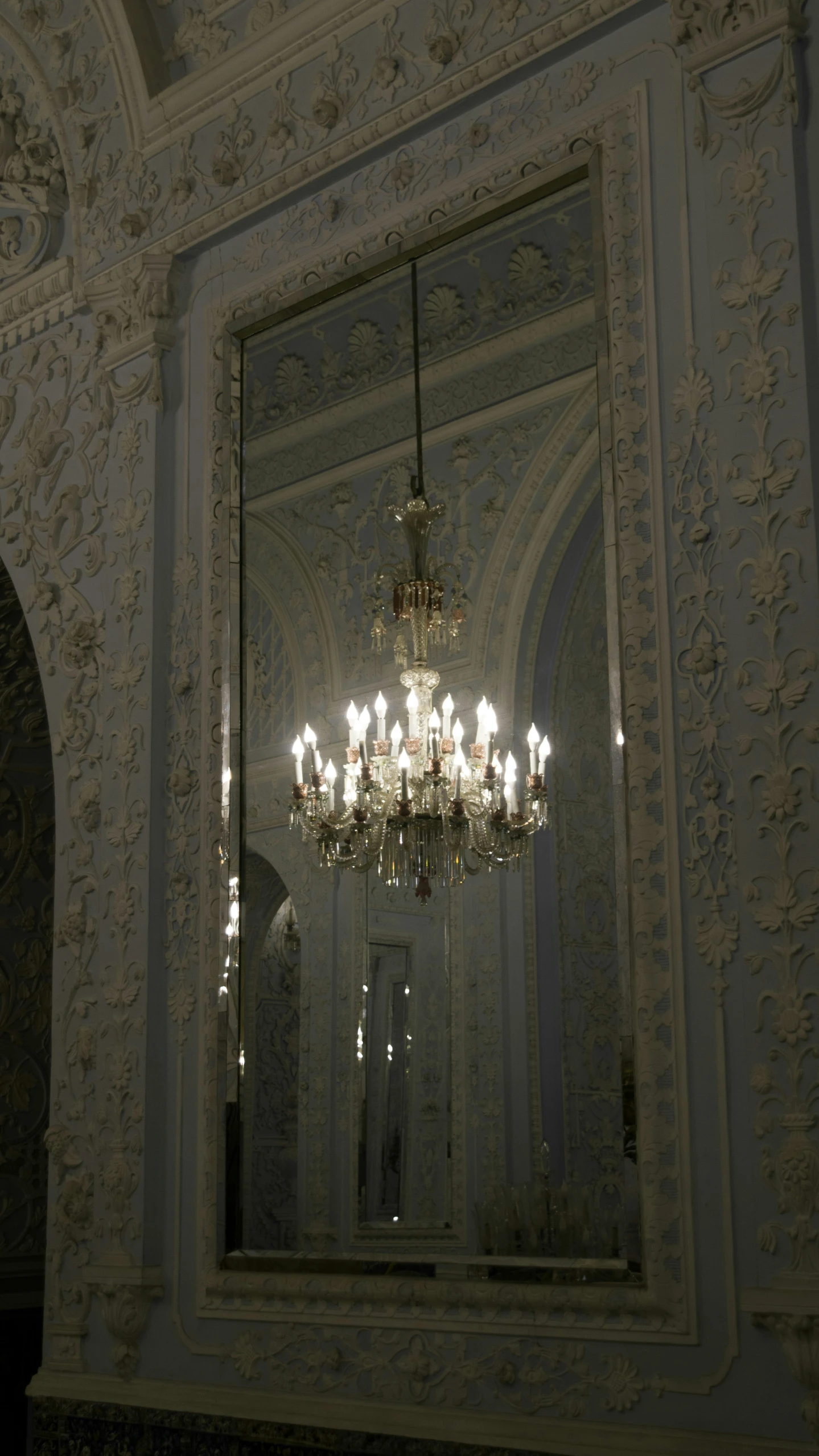 an ornate chandelier hanging from the ceiling in a room