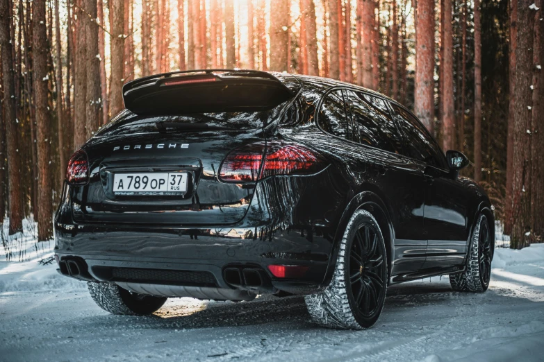 black car with ice covered rear bumpers in snowy forest