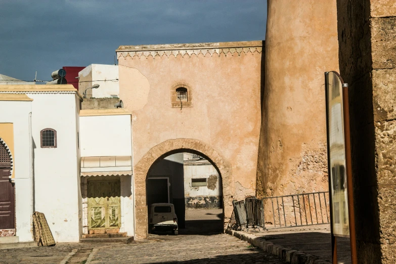 some old buildings with cars parked in the alley