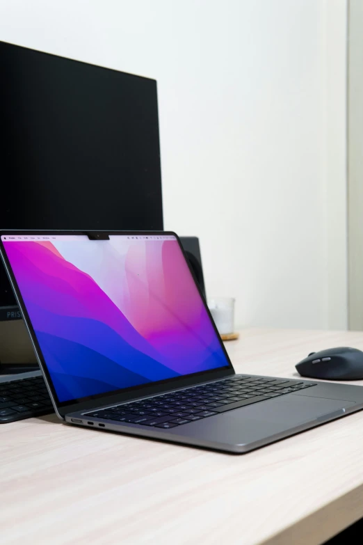 two laptops, one with a black keyboard, sit on a wooden table