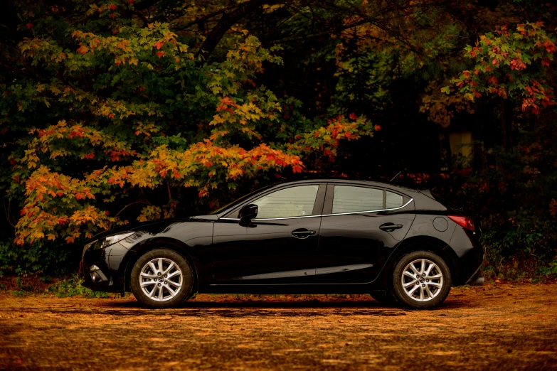 a black car is parked in the dirt