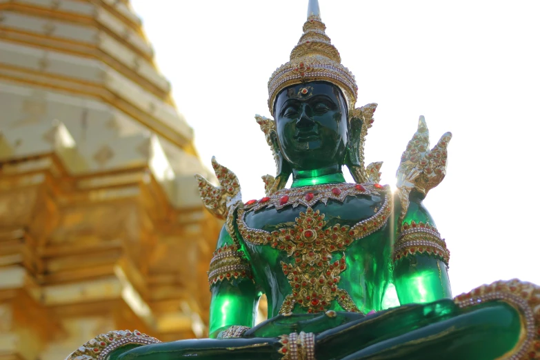 a statue is shown in front of a gold decorated building