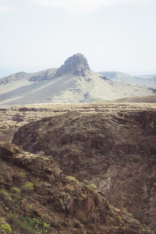 a mountain is shown in the distance from a rocky landscape