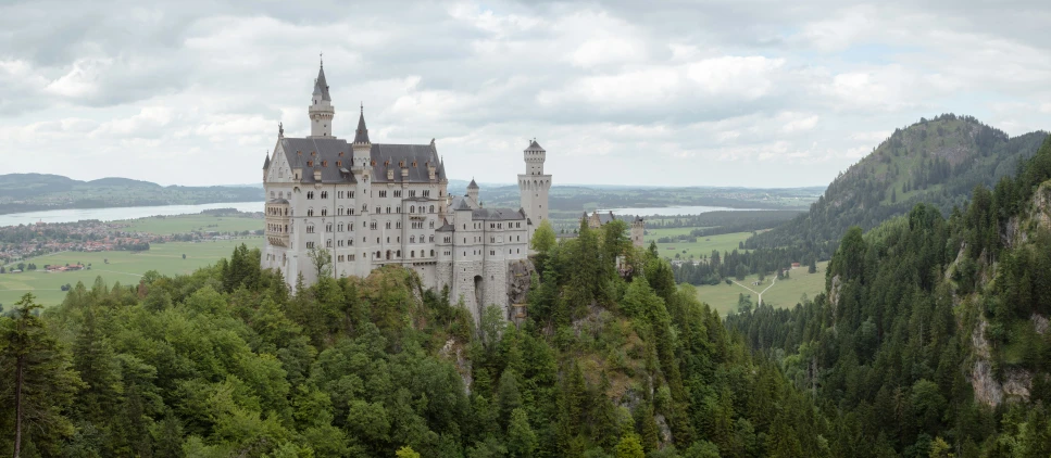 a castle built into the side of a lush green forest