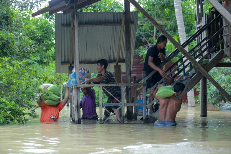 three people are working on a house on the water