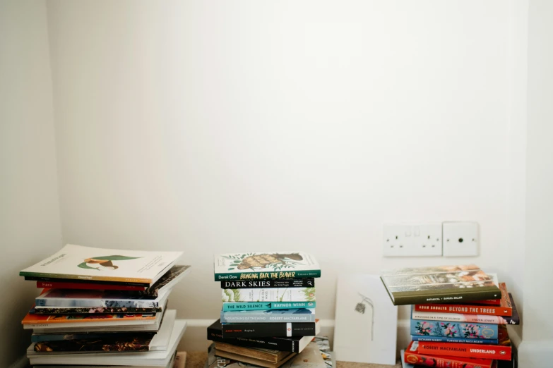 stack of books with electrical outlet on wall