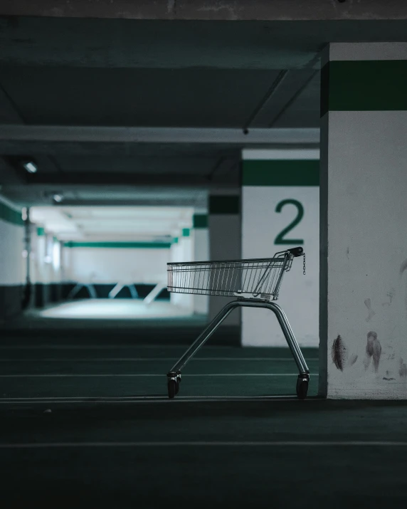 a small empty shopping cart in a dark parking garage