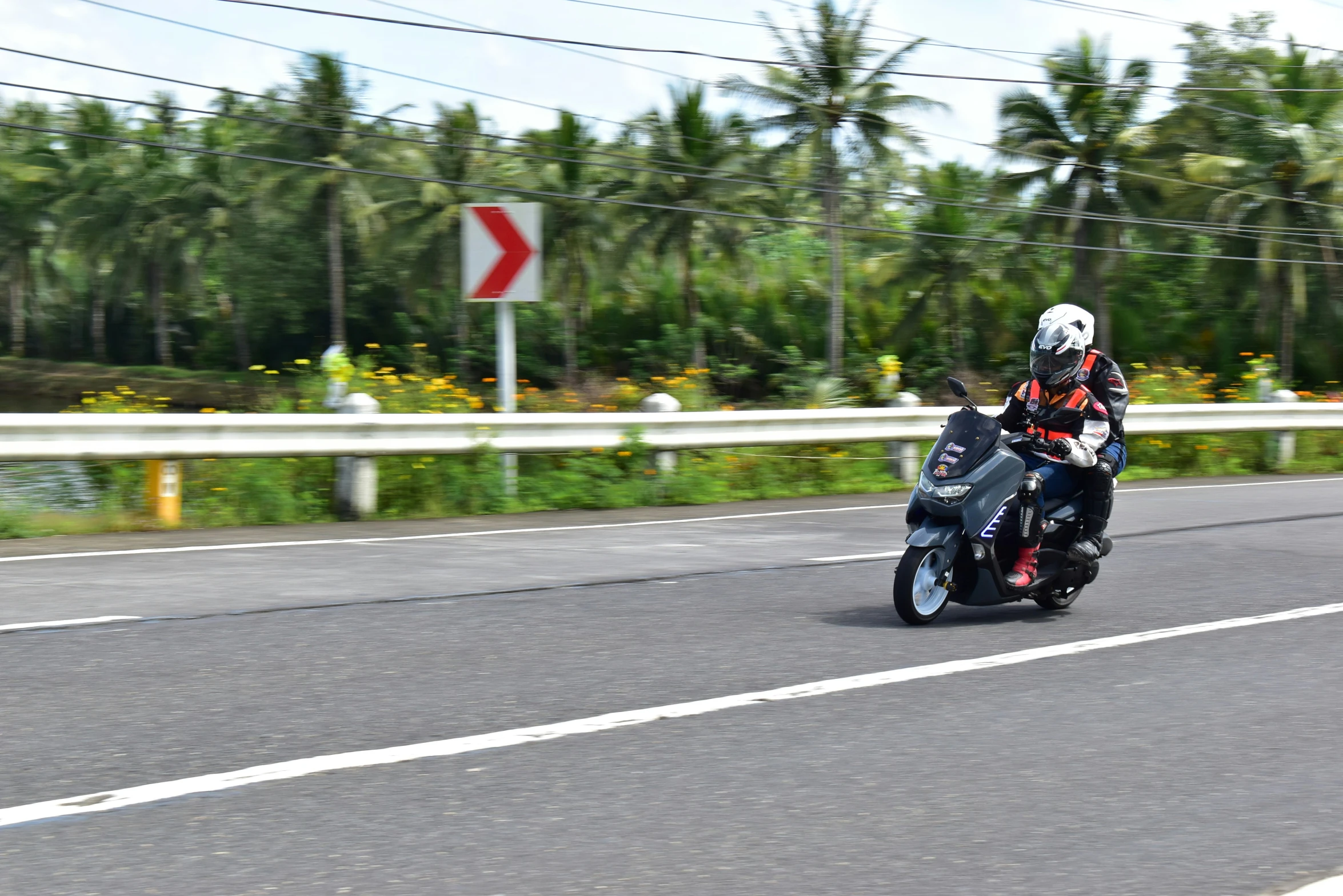 man riding on a black motorcycle with white helmet and blue jacket