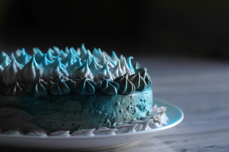 a blue cake sitting on top of a white plate