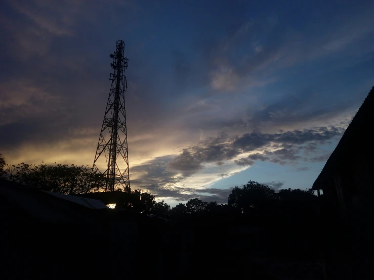 a cell tower with the sky behind it