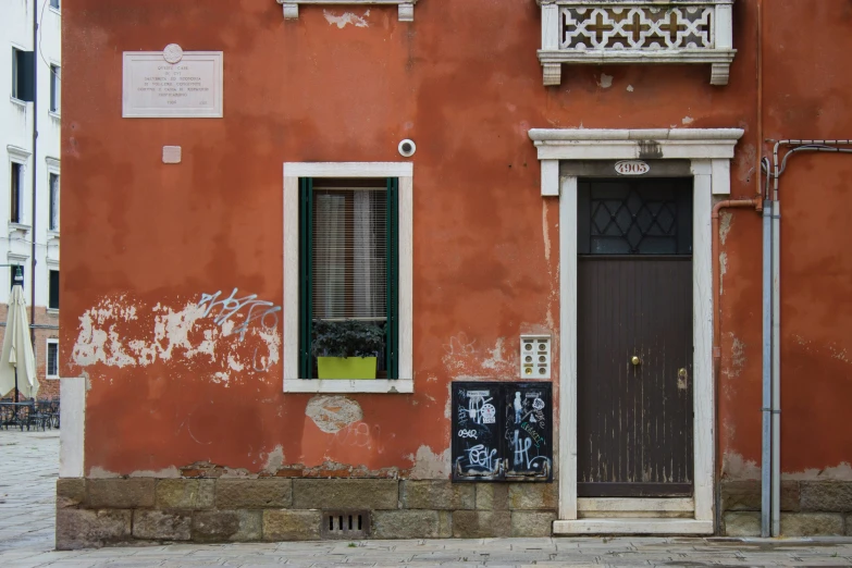 a pink building with a black door and window