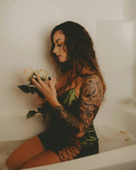 a woman in a bath tub holding flowers