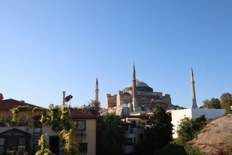 a small blue mosque sitting above a very tall building