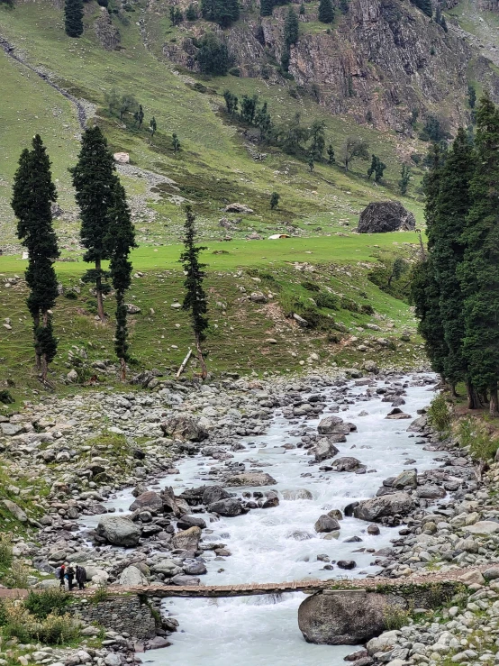 a stream flows through a rocky valley