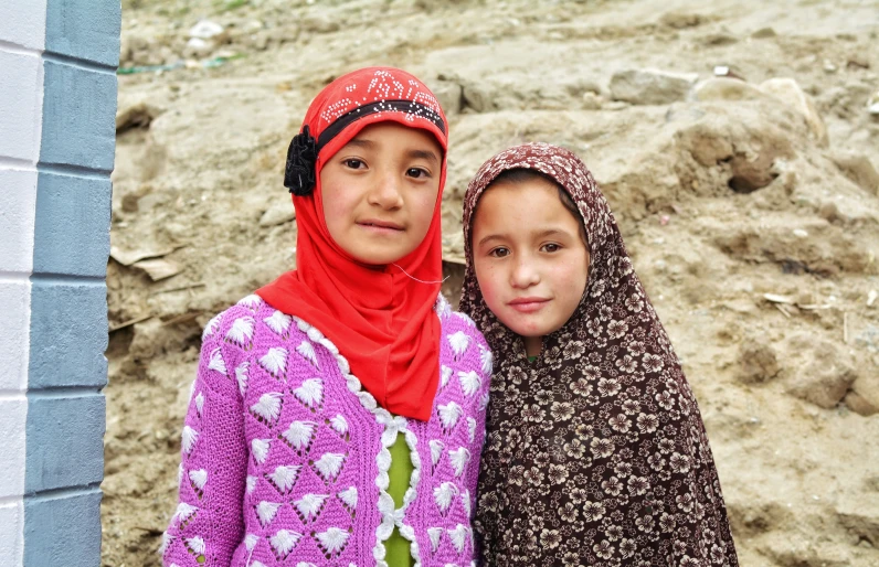 two girls are standing next to each other outside