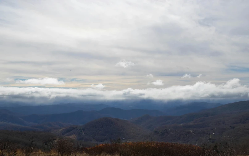 a view over the top of mountains, with low clouds