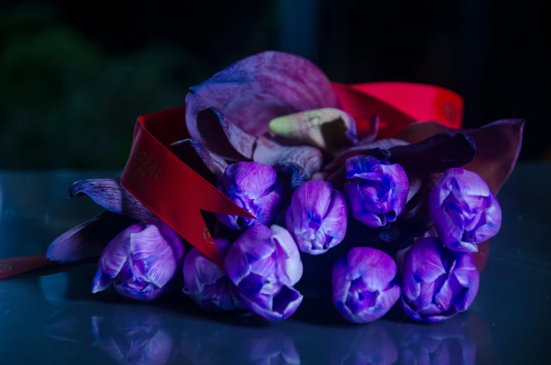 a bunch of purple flowers sitting next to a ribbon